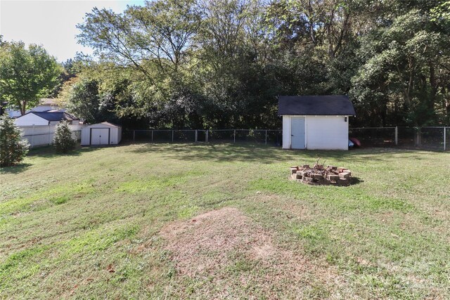 view of yard with a storage unit and a fire pit