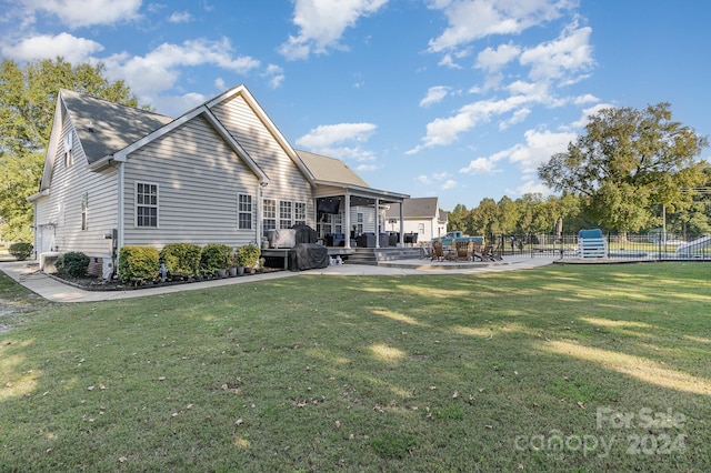 rear view of house with a patio area and a lawn