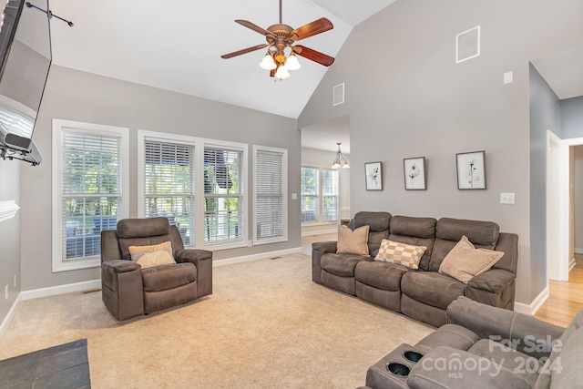 carpeted living room featuring a healthy amount of sunlight, high vaulted ceiling, and ceiling fan