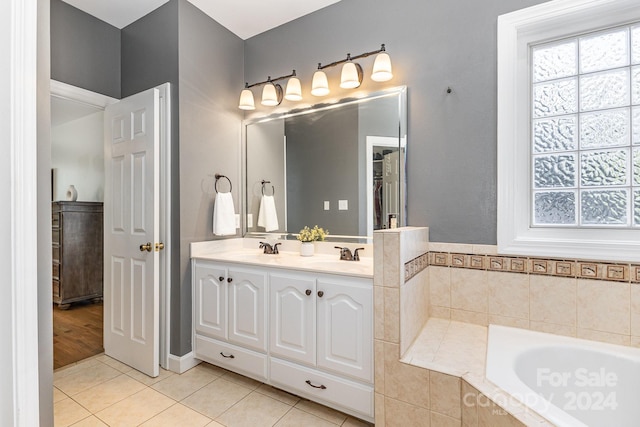 bathroom with vanity, tiled tub, and tile patterned flooring