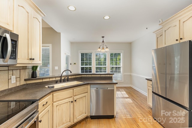 9404 Perimeter Ct, Zebulon, NC 27597 - kitchen featuring appliances with stainless steel finishes, dark countertops, light brown cabinetry, a peninsula, and recessed lighting