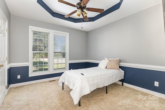 9404 Perimeter Ct, Zebulon, NC 27597 - bedroom with carpet, a tray ceiling, and ceiling fan
