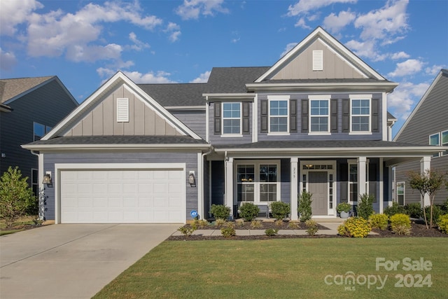 view of front facade with a porch, a garage, and a front yard