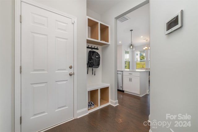 mudroom featuring dark wood-type flooring and a notable chandelier