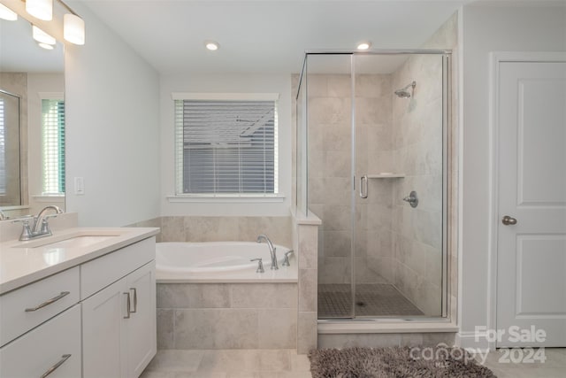 bathroom with tile patterned flooring, vanity, and independent shower and bath