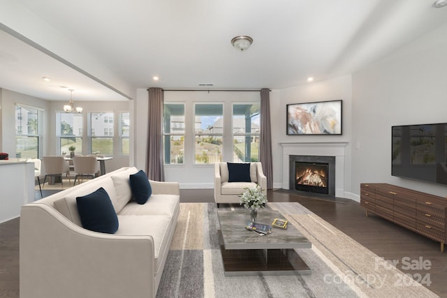 living room featuring a chandelier, a wealth of natural light, and dark wood-type flooring