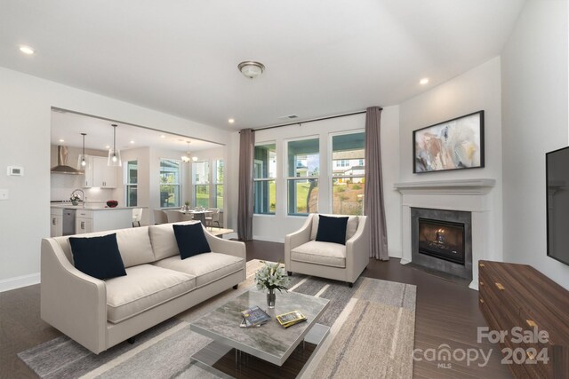 living room with an inviting chandelier and dark wood-type flooring