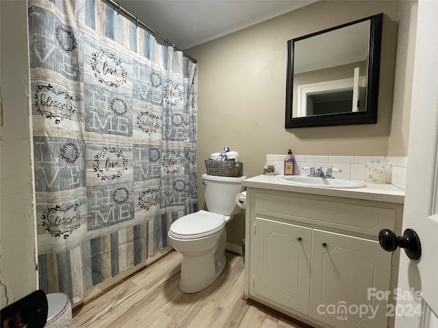 bathroom featuring hardwood / wood-style floors, vanity, toilet, and curtained shower