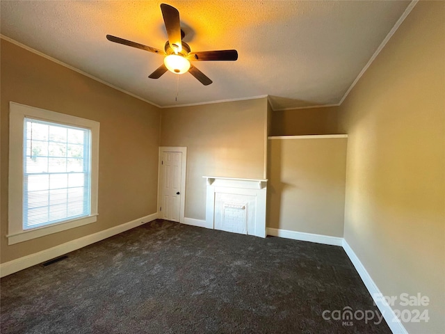 carpeted spare room featuring crown molding, ceiling fan, and a textured ceiling