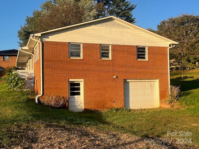 view of side of home with a garage and a lawn