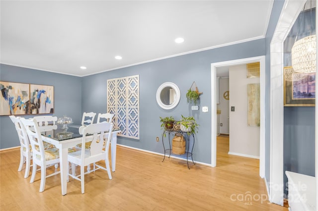 dining space featuring ornamental molding and light hardwood / wood-style floors