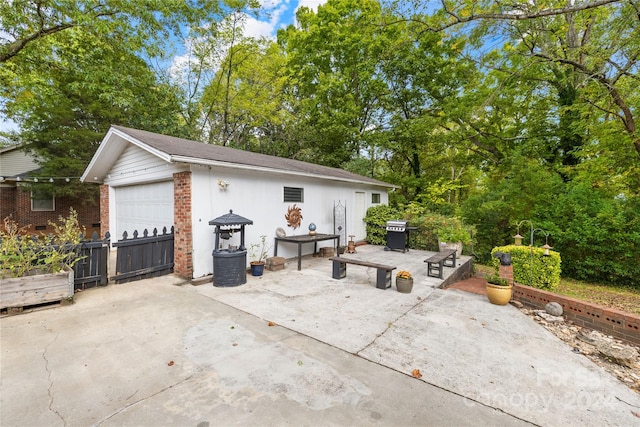 view of patio featuring a garage and a grill