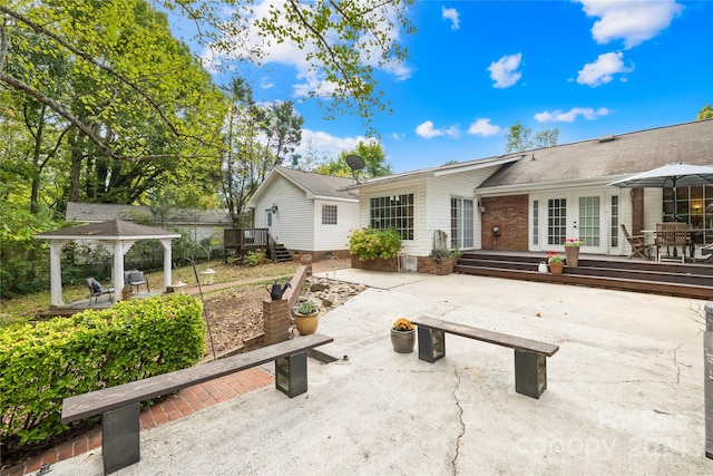 back of house with a wooden deck, a patio area, and french doors