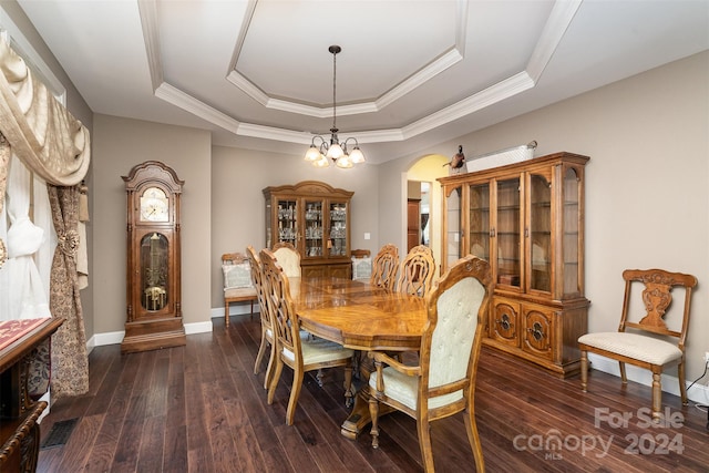 dining space featuring ornamental molding, dark hardwood / wood-style floors, a chandelier, and a raised ceiling