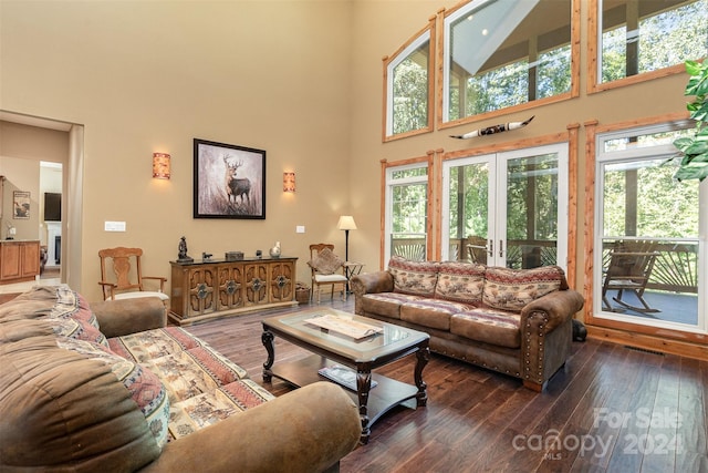 living room featuring dark wood-type flooring, a high ceiling, and french doors