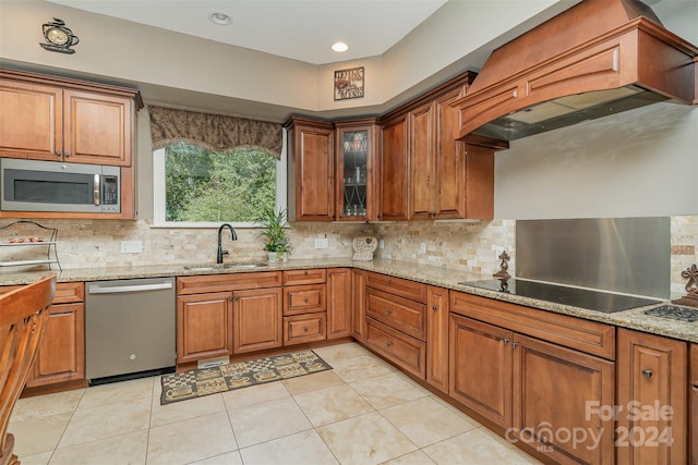 kitchen with sink, premium range hood, stainless steel appliances, and tasteful backsplash