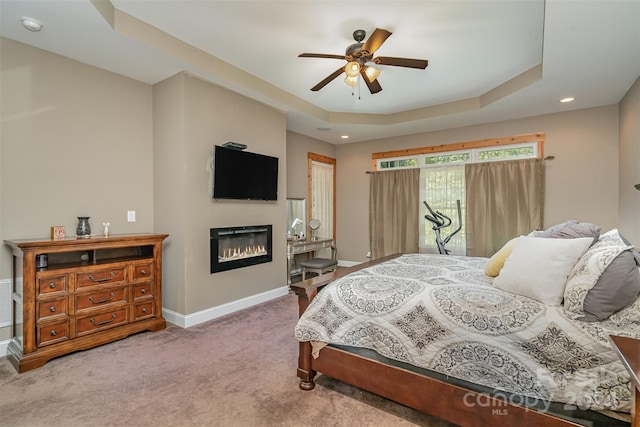 bedroom with ceiling fan, a raised ceiling, and carpet