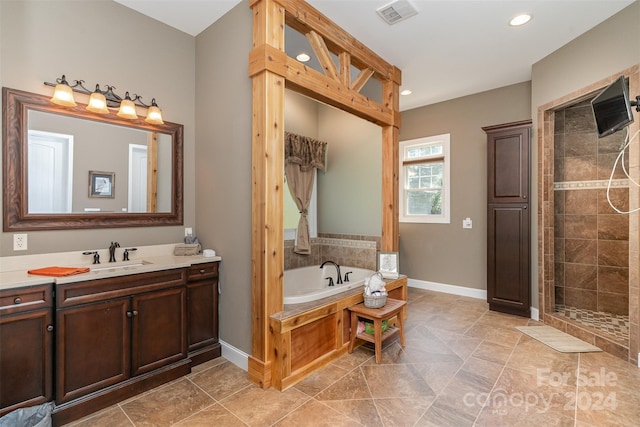 bathroom with vanity and independent shower and bath