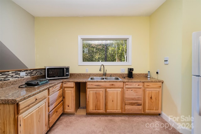 kitchen with sink, stone countertops, light carpet, and tasteful backsplash