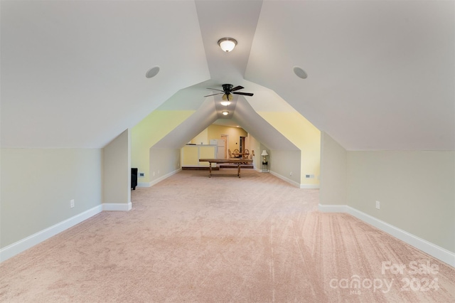 additional living space with ceiling fan, light colored carpet, and vaulted ceiling