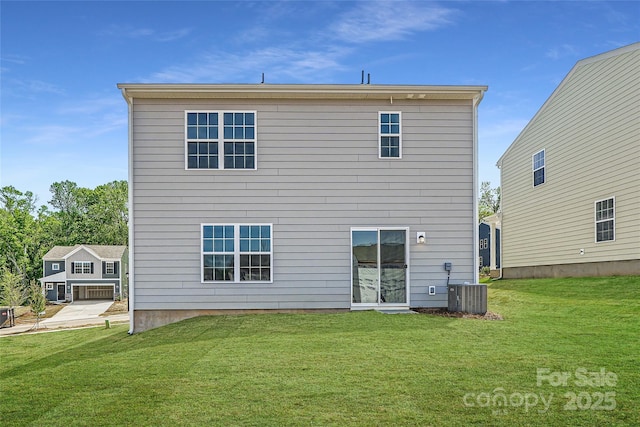 back of property featuring central air condition unit and a yard