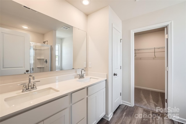 full bathroom with visible vents, a sink, and a shower stall