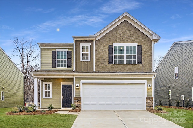 view of front of home featuring board and batten siding, a front yard, driveway, and an attached garage