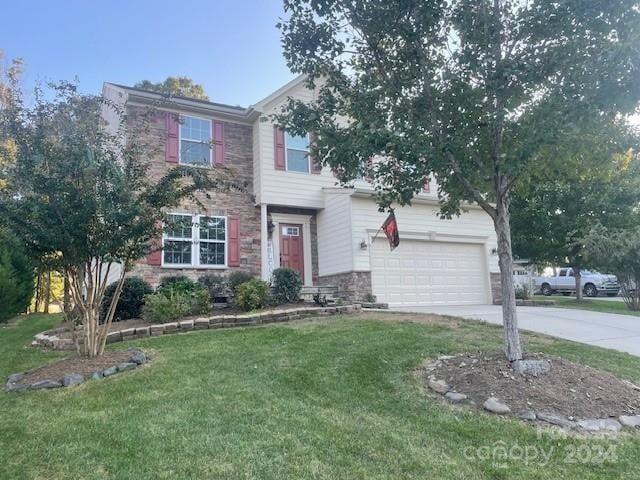 view of front of house with a garage and a front lawn