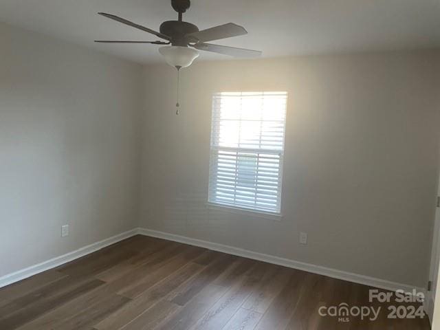 unfurnished room with dark wood-type flooring and ceiling fan