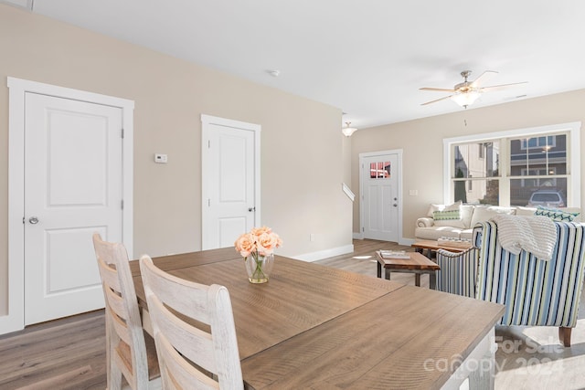 dining space with hardwood / wood-style floors and ceiling fan