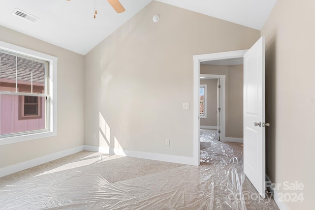 carpeted empty room featuring ceiling fan and vaulted ceiling