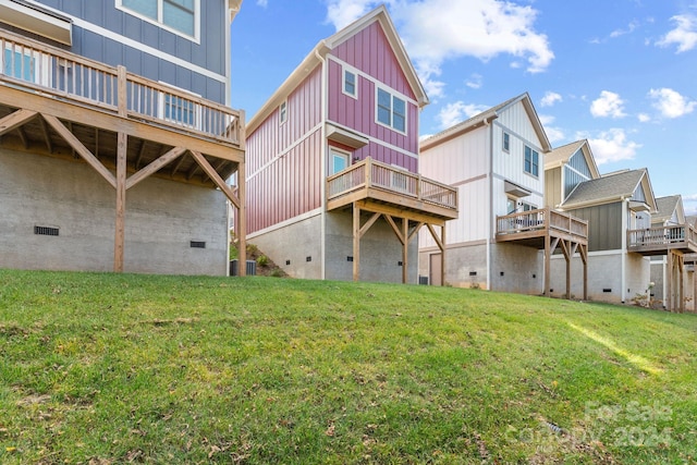 rear view of property featuring a wooden deck and a yard