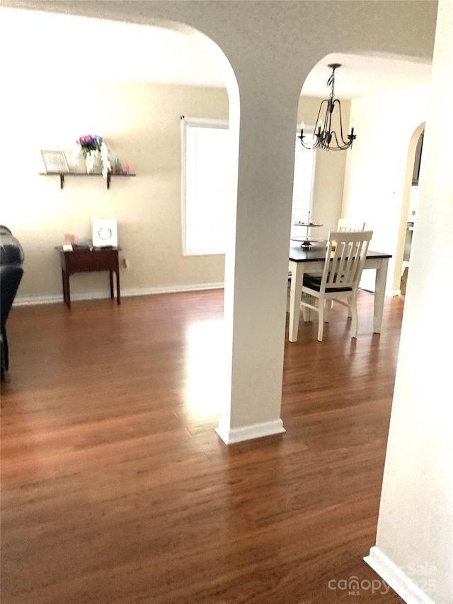 hall featuring dark hardwood / wood-style flooring and a chandelier