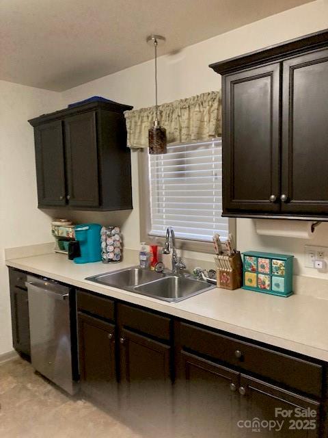 kitchen featuring dark brown cabinets, sink, and stainless steel dishwasher