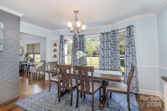 dining area featuring a chandelier, crown molding, and dark wood-type flooring