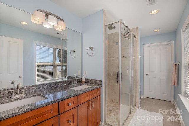 bathroom featuring vanity, tile patterned floors, and a shower with door