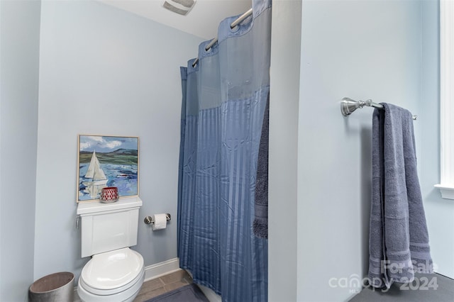 bathroom featuring toilet and curtained shower