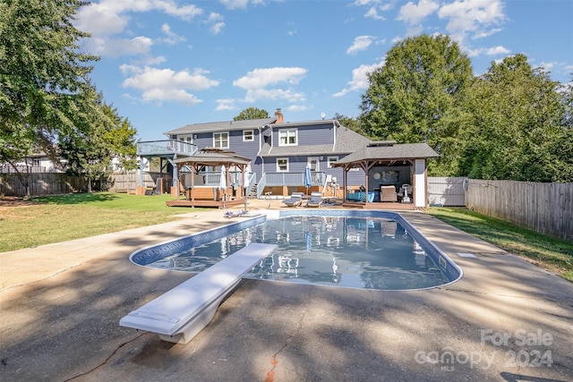 view of pool with a gazebo, a diving board, a deck, and a yard