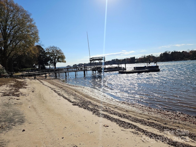 dock area with a water view and a view of the beach