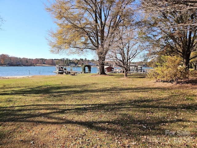 view of yard with a boat dock and a water view