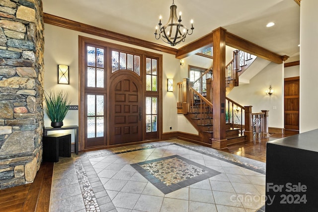 entryway featuring a notable chandelier, hardwood / wood-style flooring, and crown molding