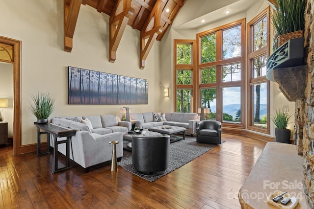 living room featuring dark hardwood / wood-style floors, beam ceiling, and high vaulted ceiling