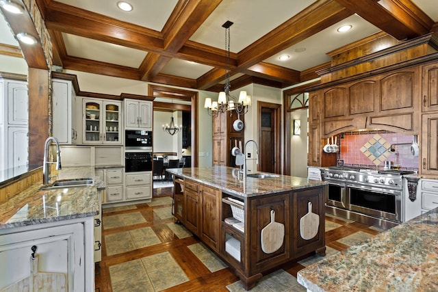 kitchen featuring an island with sink, stainless steel appliances, sink, and decorative backsplash