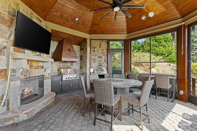 sunroom featuring a healthy amount of sunlight, ceiling fan, and wood ceiling