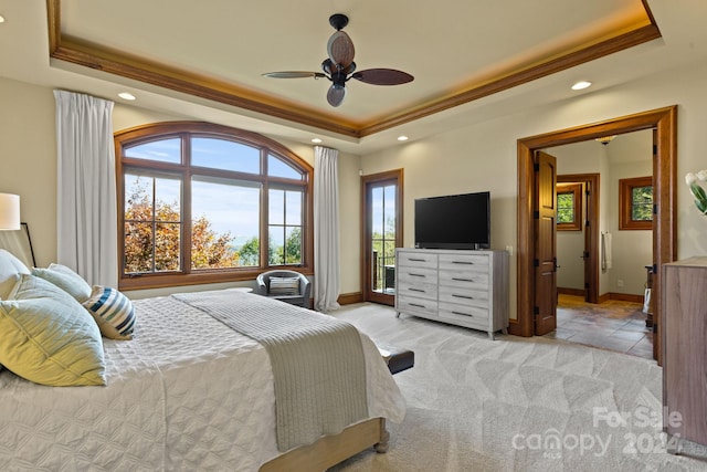 bedroom featuring ceiling fan, light colored carpet, a raised ceiling, and access to outside