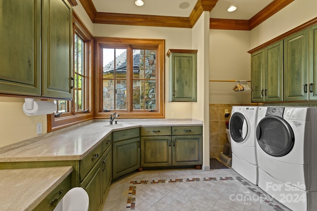 washroom with sink, crown molding, cabinets, washing machine and clothes dryer, and light tile patterned floors