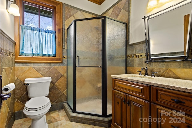 bathroom with vanity, toilet, a shower with door, and tile patterned floors