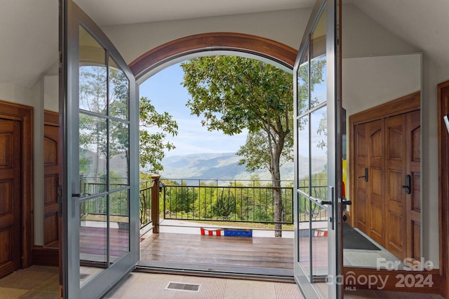 doorway to outside with a mountain view and vaulted ceiling