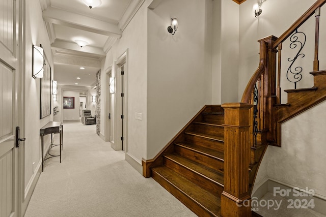 interior space with light colored carpet, beam ceiling, and ornamental molding