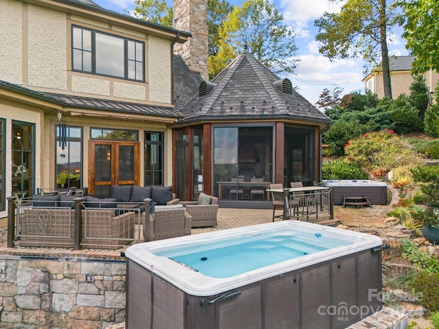 exterior space featuring an outdoor hangout area, a sunroom, and a hot tub